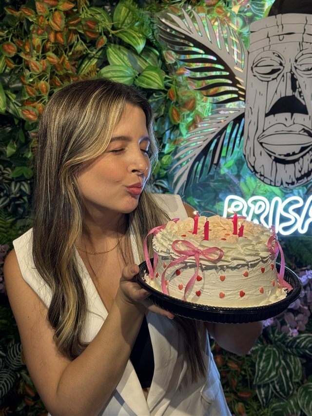 Yasmin soprando as velas de um bolo de aniversário